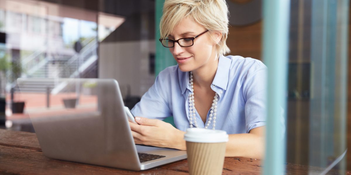 Une femme consultant l'actualité lors d'une pause café