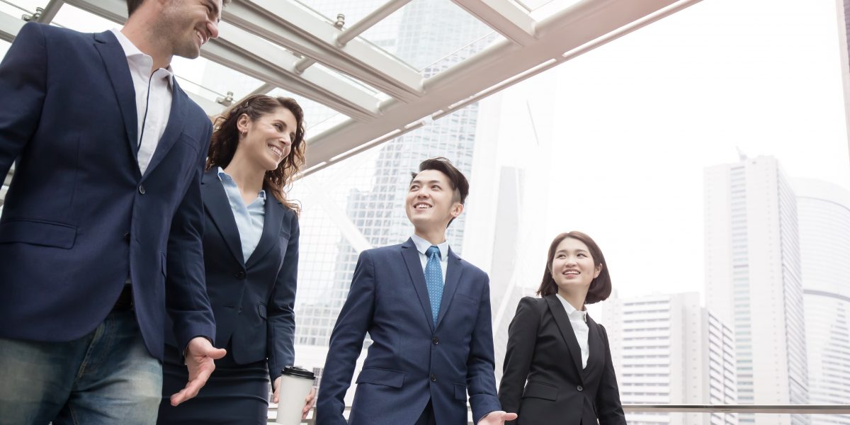 Quatre personnes en discussion dans un couloir sur leur lieu de travail