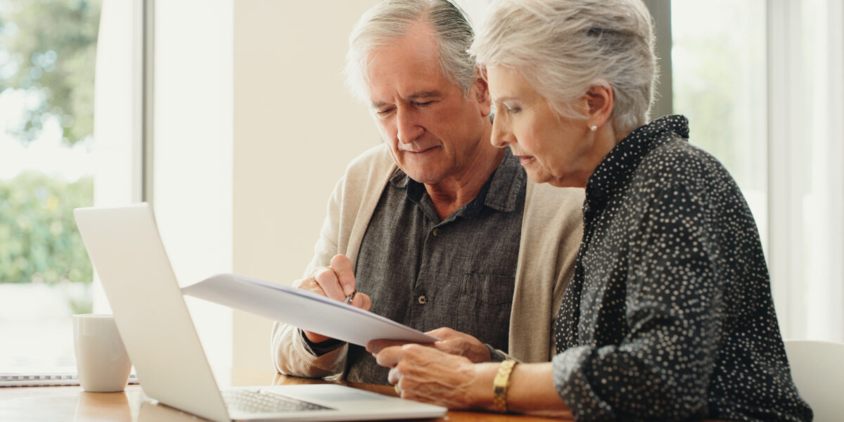 Couple de seniors analysant leurs comptes à l'aide d'un ordinateur portable