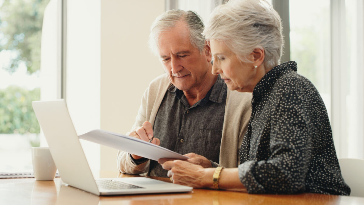 Couple de seniors analysant leurs comptes à l'aide d'un ordinateur portable